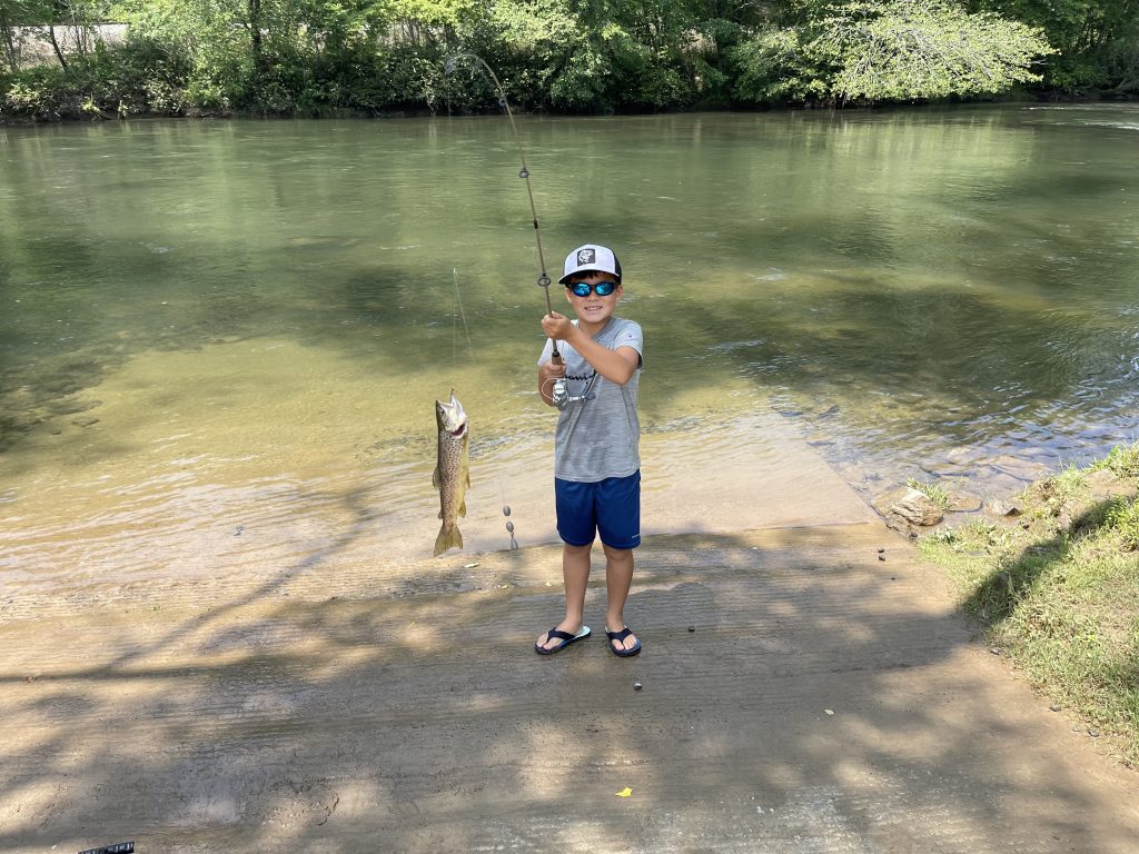 kid holding rod with trout on line kid holding rod with trout on line